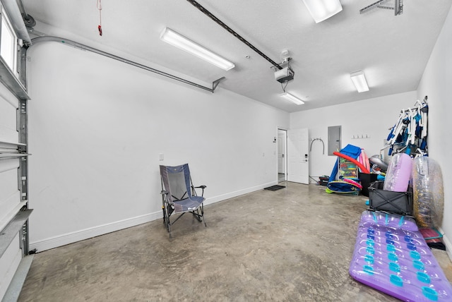 512 Dement Cir Apt F, Panama City Beach, FL 32407 - garage featuring electric panel, a garage door opener, and baseboards