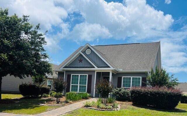 115 Lilly Bell Ln, Freeport, FL 32439 - view of front of home with a front yard, board and batten siding, and roof with shingles