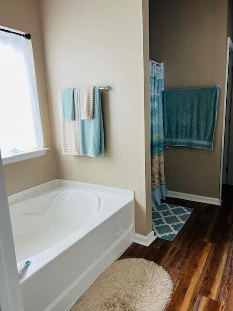 115 Lilly Bell Ln, Freeport, FL 32439 - full bath featuring wood finished floors, a bath, baseboards, and a shower with curtain