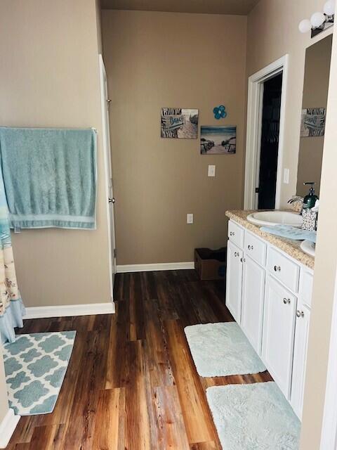 115 Lilly Bell Ln, Freeport, FL 32439 - bathroom featuring wood finished floors, double vanity, and baseboards