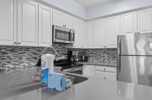 515 Topsl Beach Blvd # 401, Miramar Beach, FL 32550 - kitchen featuring appliances with stainless steel finishes, backsplash, white cabinetry, and light countertops