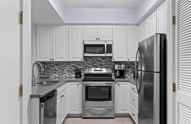 515 Topsl Beach Blvd # 401, Miramar Beach, FL 32550 - kitchen with stainless steel appliances, a sink, white cabinetry, and decorative backsplash