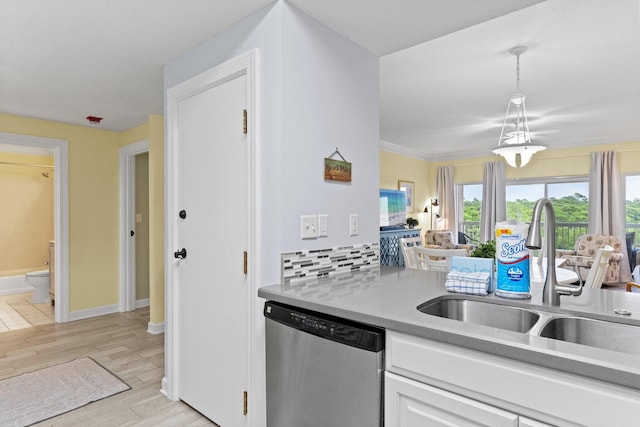 515 Topsl Beach Blvd # 401, Miramar Beach, FL 32550 - kitchen with stainless steel dishwasher, a sink, white cabinetry, light countertops, and light wood-type flooring
