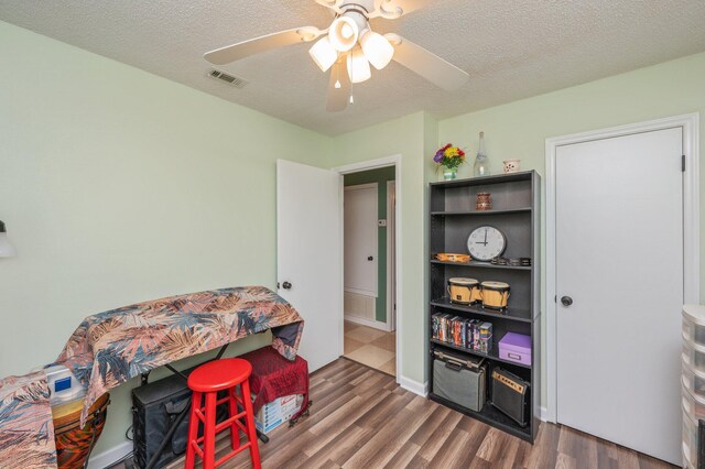 6256 Misty Ln, Crestview, FL 32539 - rec room with dark wood-type flooring, a textured ceiling, and a ceiling fan