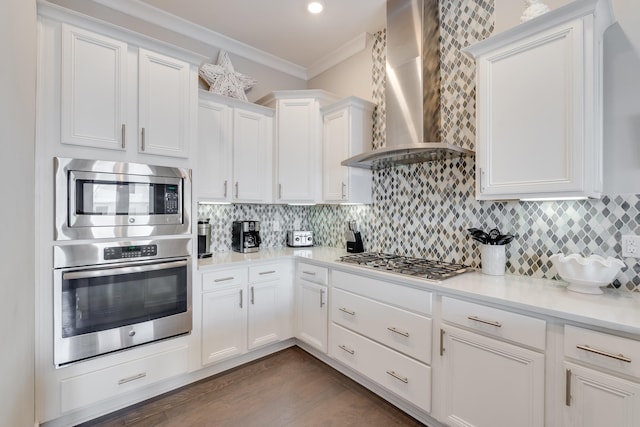 23 E York Ln Unit C, Inlet Beach, FL 32461 - kitchen featuring appliances with stainless steel finishes, ornamental molding, wall chimney range hood, white cabinets, and light countertops