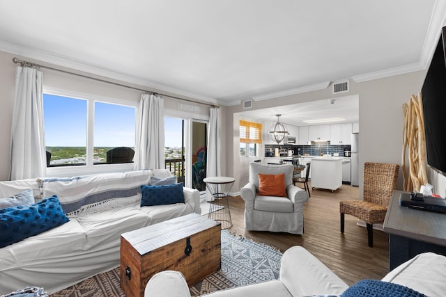 23223 Front Beach Rd # 913, Panama City Beach, FL 32413 - living area with crown molding, light wood-type flooring, and a chandelier