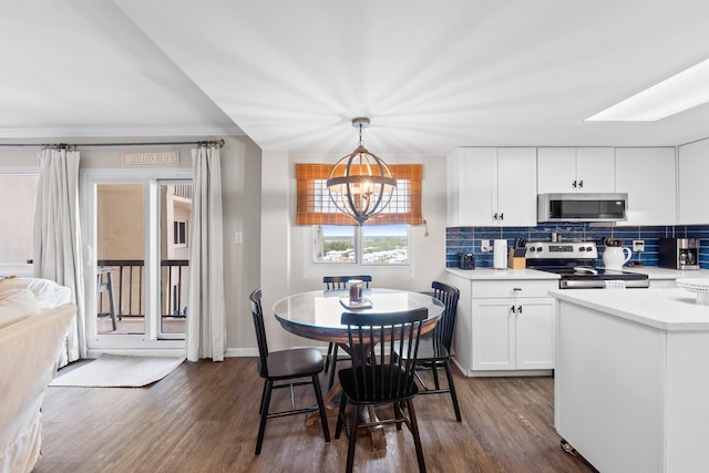 23223 Front Beach Rd # 913, Panama City Beach, FL 32413 - kitchen featuring appliances with stainless steel finishes, dark wood-type flooring, light countertops, backsplash, and white cabinets
