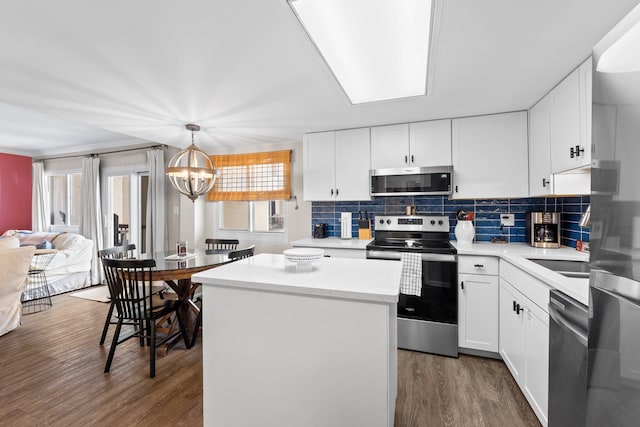 23223 Front Beach Rd # 913, Panama City Beach, FL 32413 - kitchen featuring appliances with stainless steel finishes, dark wood finished floors, a center island, a chandelier, and tasteful backsplash