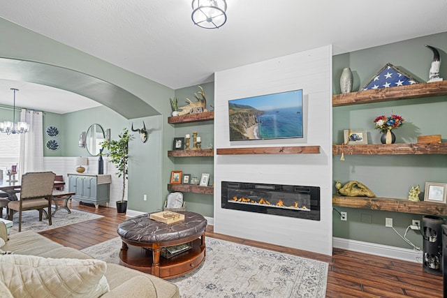 5416 Mill Brook Ln, Crestview, FL 32539 - living area with wood finished floors, a chandelier, a large fireplace, and arched walkways