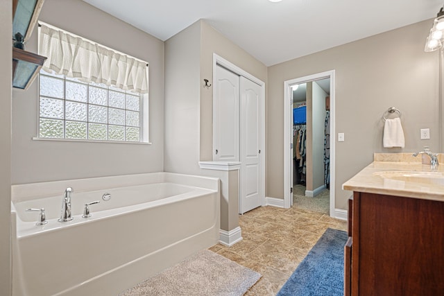 5416 Mill Brook Ln, Crestview, FL 32539 - bathroom with vanity, a bath, baseboards, and a spacious closet