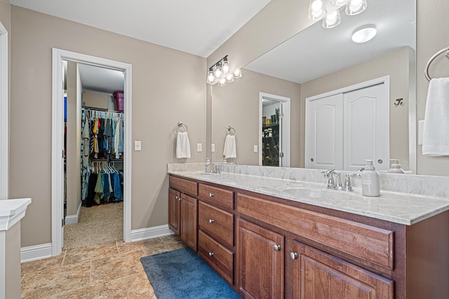 5416 Mill Brook Ln, Crestview, FL 32539 - bathroom with double vanity, a spacious closet, baseboards, and tile patterned floors