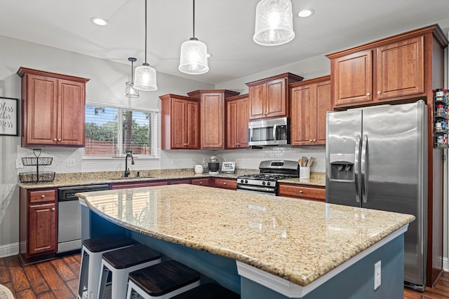 5416 Mill Brook Ln, Crestview, FL 32539 - kitchen featuring appliances with stainless steel finishes, a sink, a center island, dark wood-style floors, and light stone countertops
