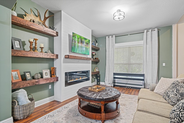 5416 Mill Brook Ln, Crestview, FL 32539 - living area featuring wood finished floors, a glass covered fireplace, and baseboards