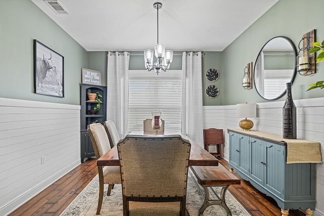 5416 Mill Brook Ln, Crestview, FL 32539 - dining area with a chandelier, dark wood-style floors, wooden walls, and wainscoting