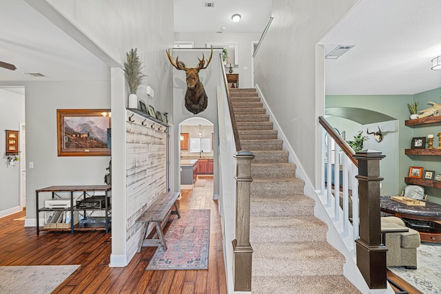 5416 Mill Brook Ln, Crestview, FL 32539 - stairs with arched walkways, wood finished floors, baseboards, and a ceiling fan