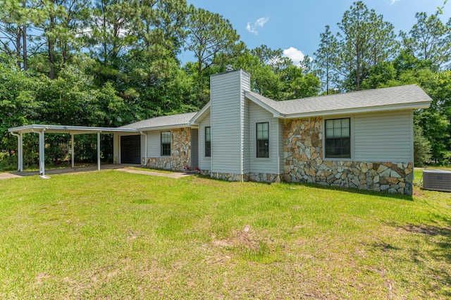 5951 N Meadow Ln, Crestview, FL 32539 - view of side of property featuring cooling unit, a garage, stone siding, a chimney, and a carport