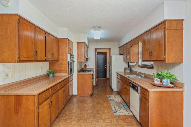 5951 N Meadow Ln, Crestview, FL 32539 - kitchen with stainless steel appliances, a sink, brown cabinets, and a textured ceiling