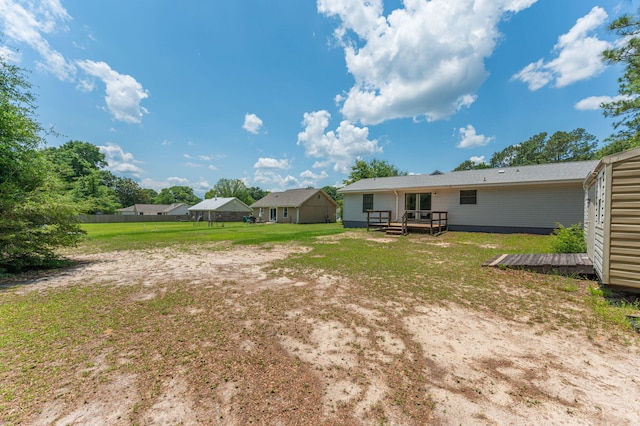 5951 N Meadow Ln, Crestview, FL 32539 - view of green lawn featuring a wooden deck and an outdoor structure