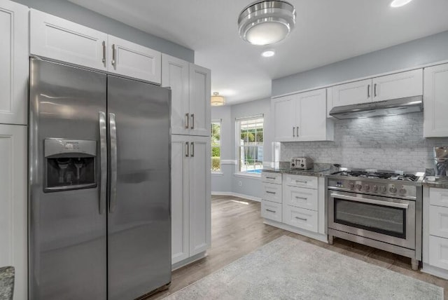14 Winfield Way, Mary Esther, FL 32569 - kitchen featuring stainless steel appliances, under cabinet range hood, backsplash, light wood-style flooring, and white cabinetry