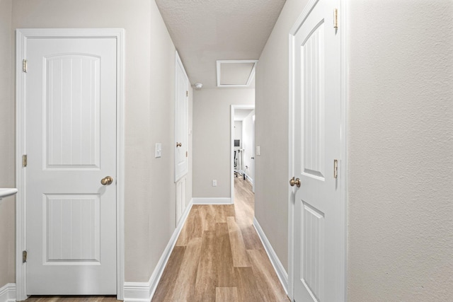 64 Crossing Ln Unit E, Santa Rosa Beach, FL 32459 - corridor featuring light wood-style flooring, baseboards, and a textured ceiling