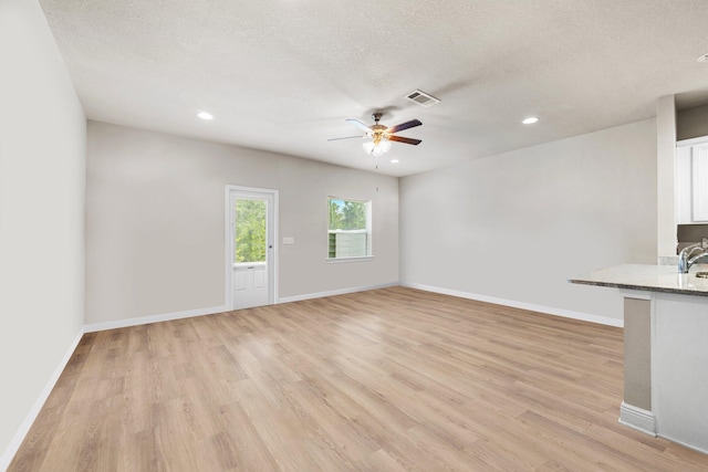 64 Crossing Ln Unit E, Santa Rosa Beach, FL 32459 - unfurnished living room featuring ceiling fan, light wood-style flooring, recessed lighting, baseboards, and a textured ceiling