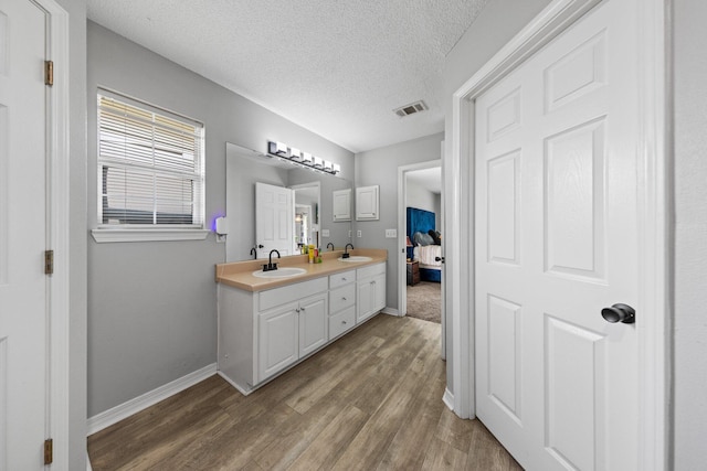 5123 Whitehurst Ln, Crestview, FL 32536 - full bath featuring double vanity, wood finished floors, connected bathroom, and a textured ceiling