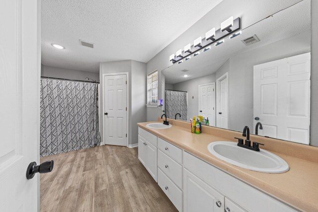 5123 Whitehurst Ln, Crestview, FL 32536 - bathroom with double vanity, wood finished floors, and a textured ceiling