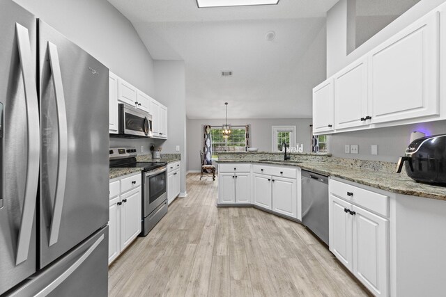 5123 Whitehurst Ln, Crestview, FL 32536 - kitchen with appliances with stainless steel finishes, light wood finished floors, white cabinets, a peninsula, and light stone countertops
