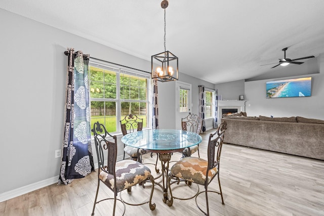 5123 Whitehurst Ln, Crestview, FL 32536 - dining space featuring a chandelier, light wood-type flooring, a lit fireplace, and ceiling fan