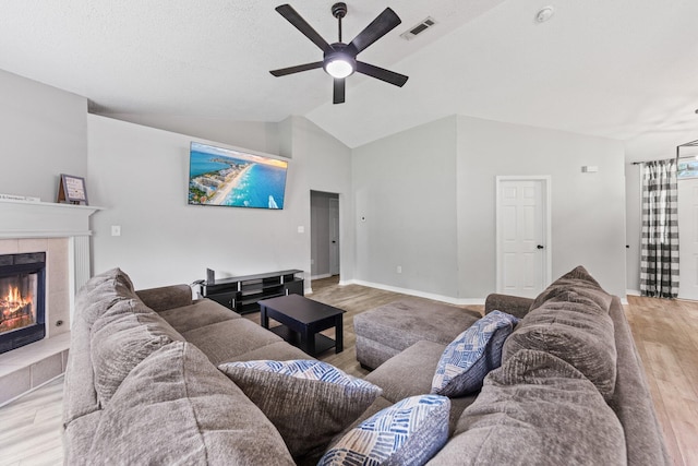 5123 Whitehurst Ln, Crestview, FL 32536 - living area featuring wood finished floors, ceiling fan, vaulted ceiling, and a tiled fireplace