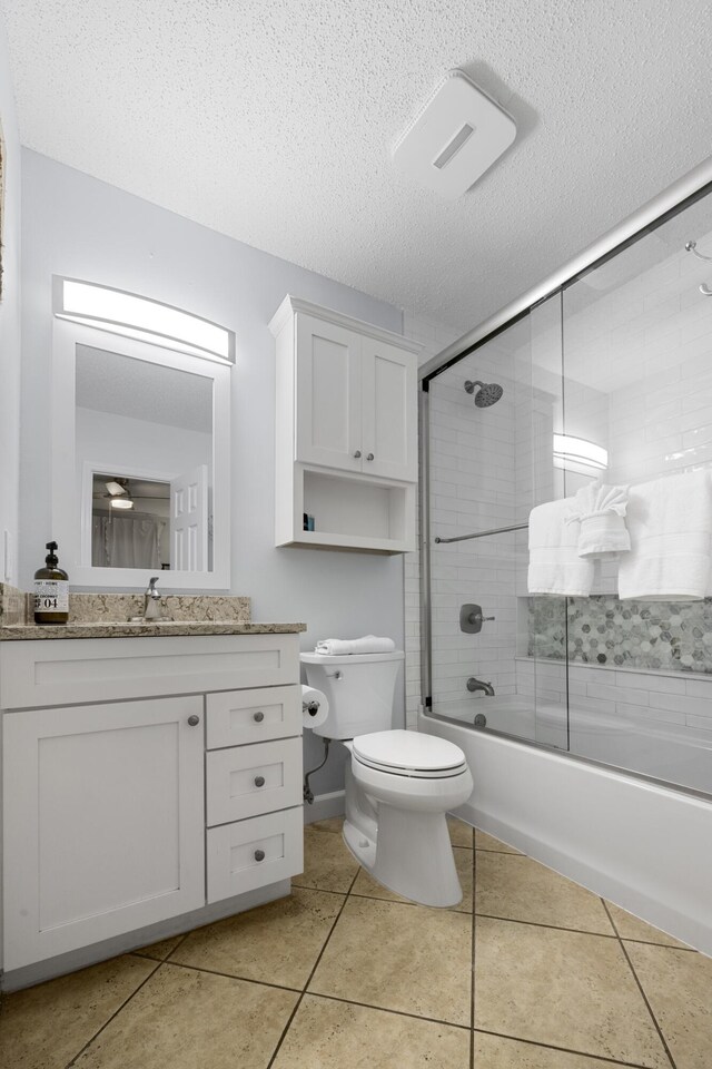 2606 Scenic Gulf Dr Unit 2412, Miramar Beach, FL 32550 - full bathroom with toilet, vanity, shower / bath combination with glass door, a textured ceiling, and tile patterned floors