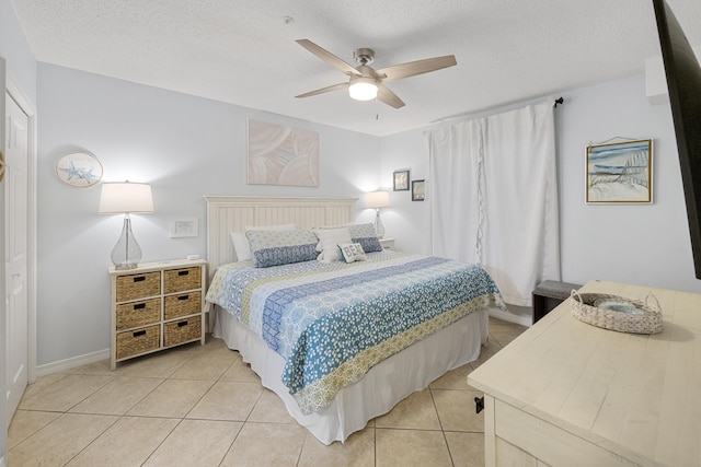 2606 Scenic Gulf Dr Unit 2412, Miramar Beach, FL 32550 - bedroom featuring light tile patterned floors, a ceiling fan, a textured ceiling, and baseboards