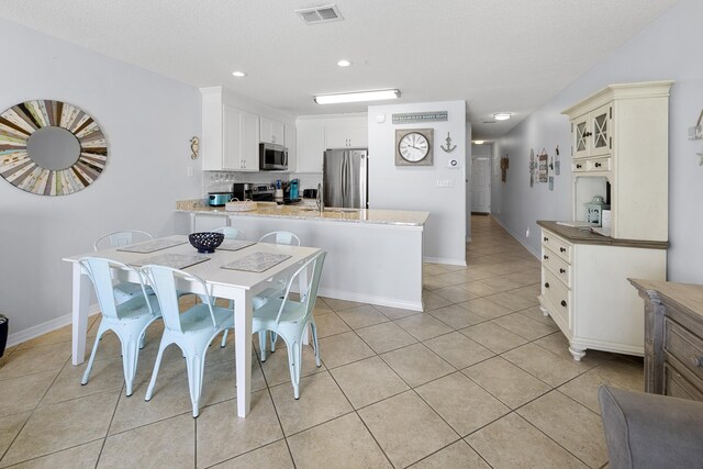 2606 Scenic Gulf Dr Unit 2412, Miramar Beach, FL 32550 - dining area with light tile patterned flooring, baseboards, recessed lighting, and a textured ceiling