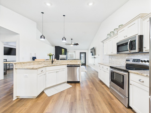 5740 Marigold Loop, Crestview, FL 32539 - kitchen with stainless steel appliances, light wood finished floors, vaulted ceiling, a sink, and white cabinetry