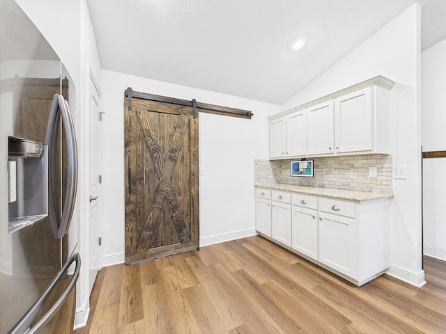 5740 Marigold Loop, Crestview, FL 32539 - kitchen featuring stainless steel fridge, light wood finished floors, lofted ceiling, and backsplash
