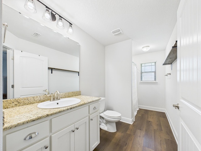 5740 Marigold Loop, Crestview, FL 32539 - bathroom with toilet, vanity, wood finished floors, baseboards, and a shower with shower curtain