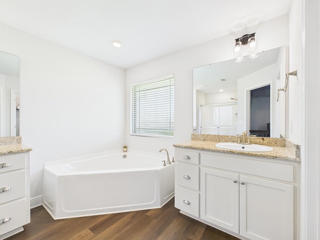 5740 Marigold Loop, Crestview, FL 32539 - bathroom featuring vanity, wood finished floors, a garden tub, and a shower stall