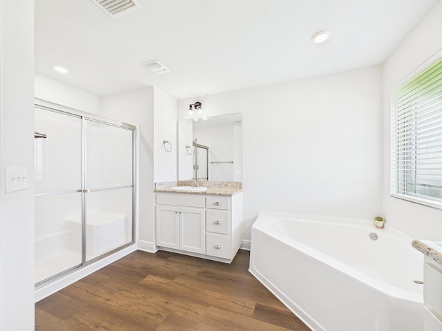 5740 Marigold Loop, Crestview, FL 32539 - bathroom featuring vanity, a bath, wood finished floors, a shower stall, and recessed lighting