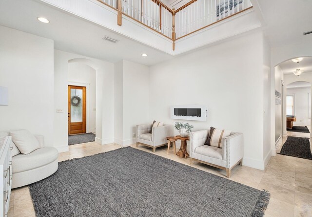 92 Carolyn Ln, Santa Rosa Beach, FL 32459 - sitting room featuring arched walkways, a towering ceiling, recessed lighting, baseboards, and tile patterned flooring