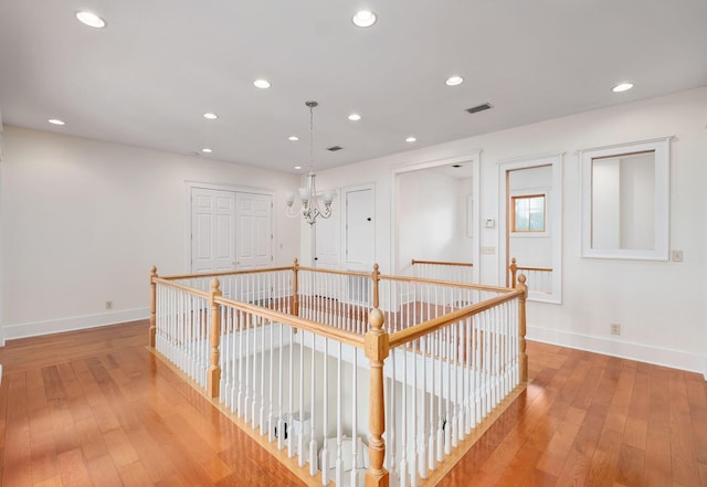 92 Carolyn Ln, Santa Rosa Beach, FL 32459 - corridor with baseboards, light wood-style floors, a chandelier, recessed lighting, and an upstairs landing
