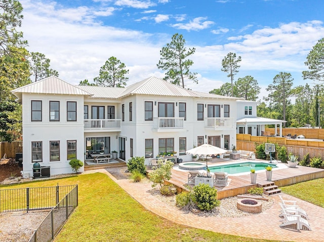 92 Carolyn Ln, Santa Rosa Beach, FL 32459 - rear view of property with an outdoor fire pit, a balcony, an in-ground hot tub, a patio area, and stucco siding