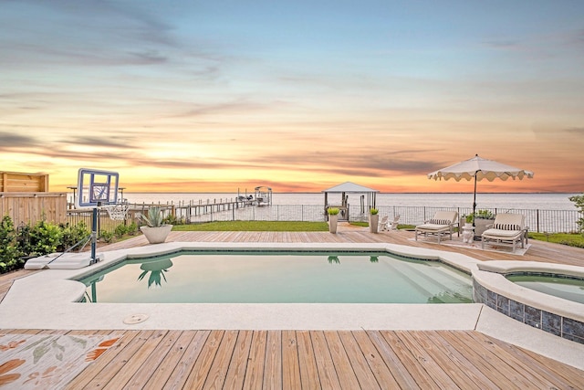 92 Carolyn Ln, Santa Rosa Beach, FL 32459 - pool at dusk featuring an in-ground hot tub and a deck with water view