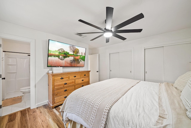 29 SE Alexandra Pl, Fort Walton Beach, FL 32548 - bedroom with two closets, light wood finished floors, ensuite bath, and a ceiling fan