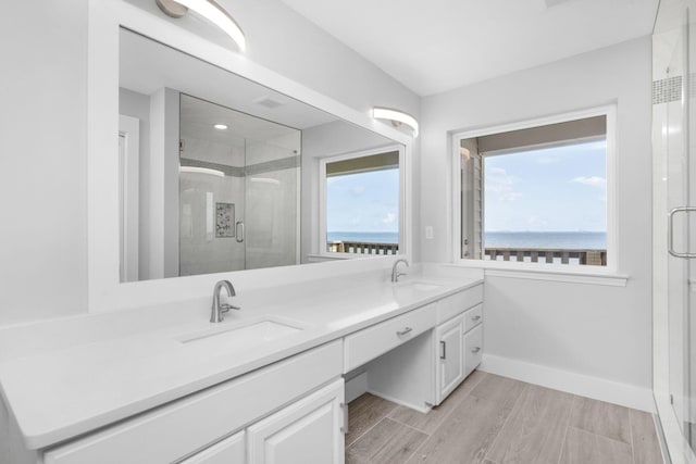 14351 State Highway 20, Niceville, FL 32578 - bathroom with double vanity, a shower stall, a water view, and wood finished floors