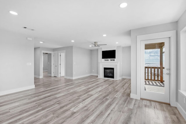 14351 State Highway 20, Niceville, FL 32578 - unfurnished living room with recessed lighting, a glass covered fireplace, light wood-type flooring, and ceiling fan
