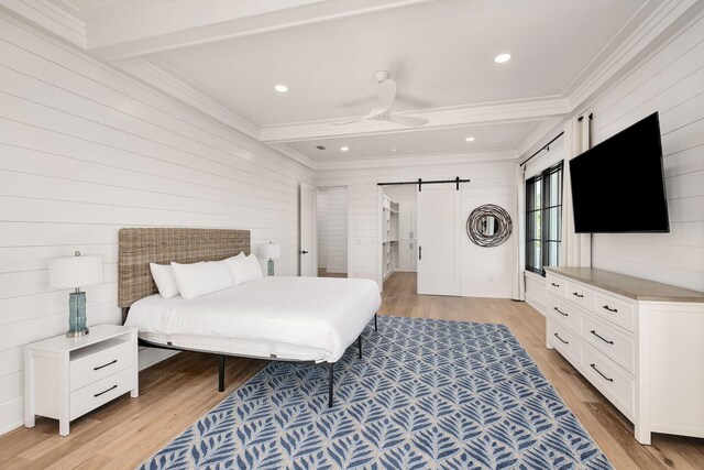 7570 E County Highway 30a, Watersound, FL 32461 - bedroom featuring a barn door, ornamental molding, light wood-style flooring, recessed lighting, and wooden walls