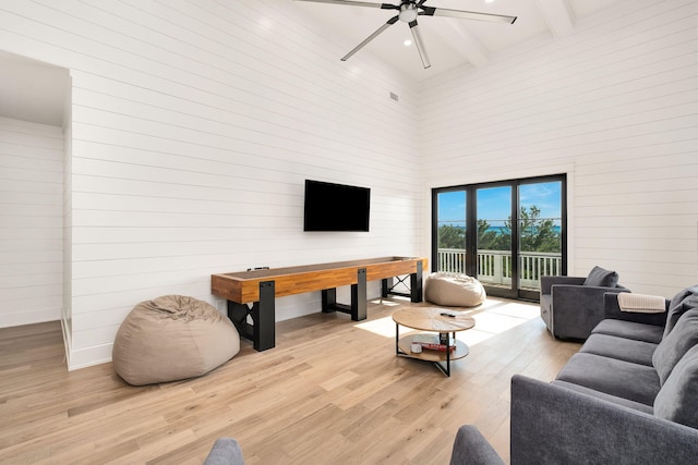 7570 E County Highway 30a, Watersound, FL 32461 - living room with a high ceiling, a ceiling fan, light wood finished floors, beam ceiling, and wooden walls