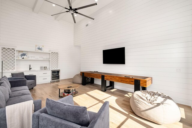 7570 E County Highway 30a, Watersound, FL 32461 - living area featuring wine cooler, a bar, light wood-type flooring, a high ceiling, and recessed lighting