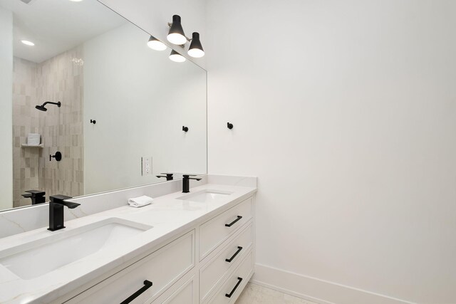 7570 E County Highway 30a, Watersound, FL 32461 - bathroom with double vanity, tiled shower, baseboards, and recessed lighting