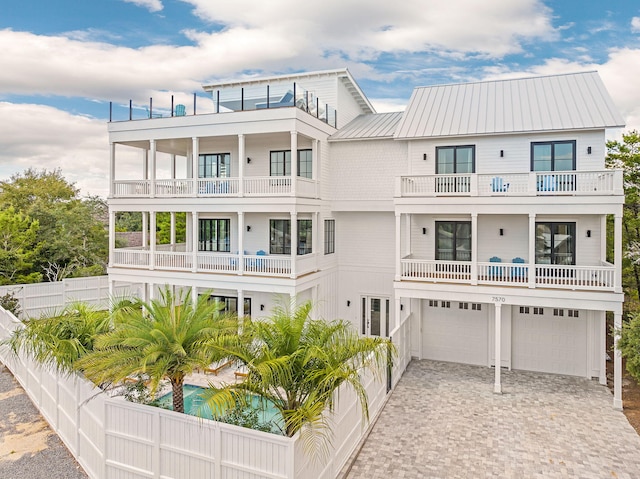 7570 E County Highway 30a, Watersound, FL 32461 - rear view of property featuring a balcony, a garage, driveway, and metal roof
